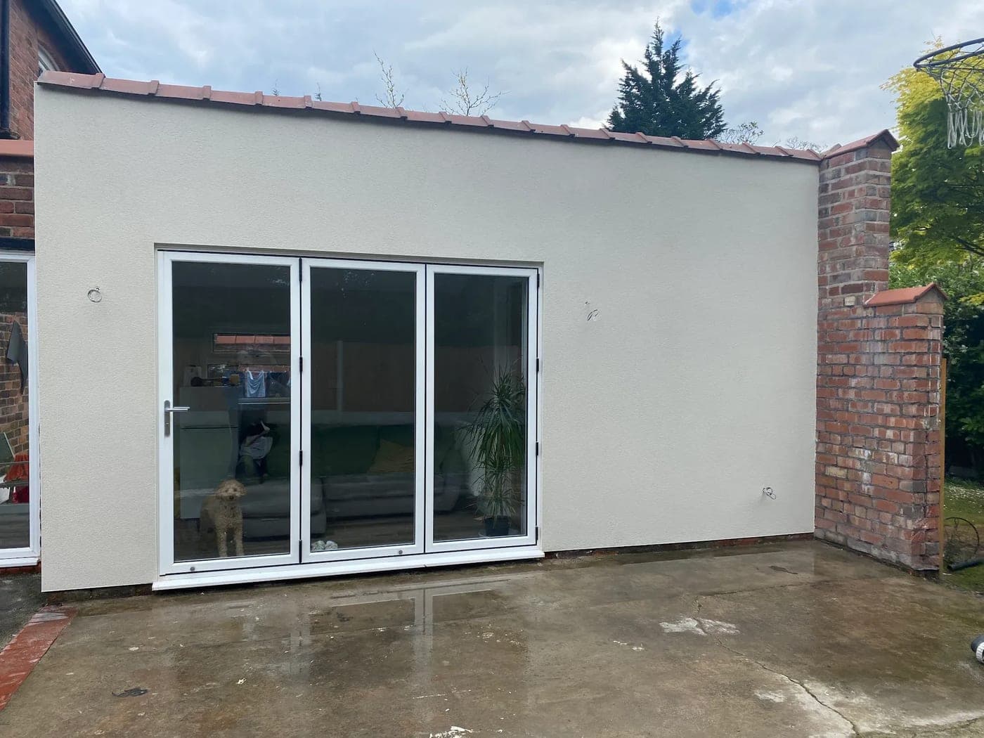 Single-storey rear extension finished in white render, with bi-fold doors and the original brickwork left exposed alongside