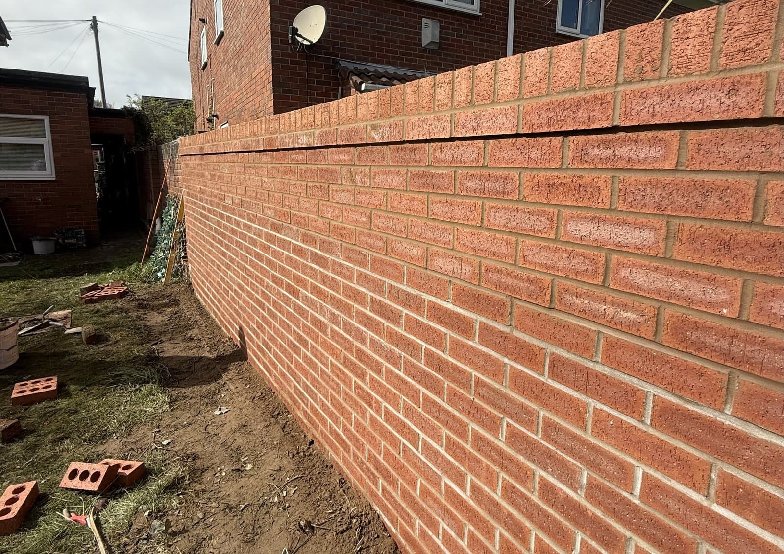 Newly built red brick garden wall with neatly struck mortar joints