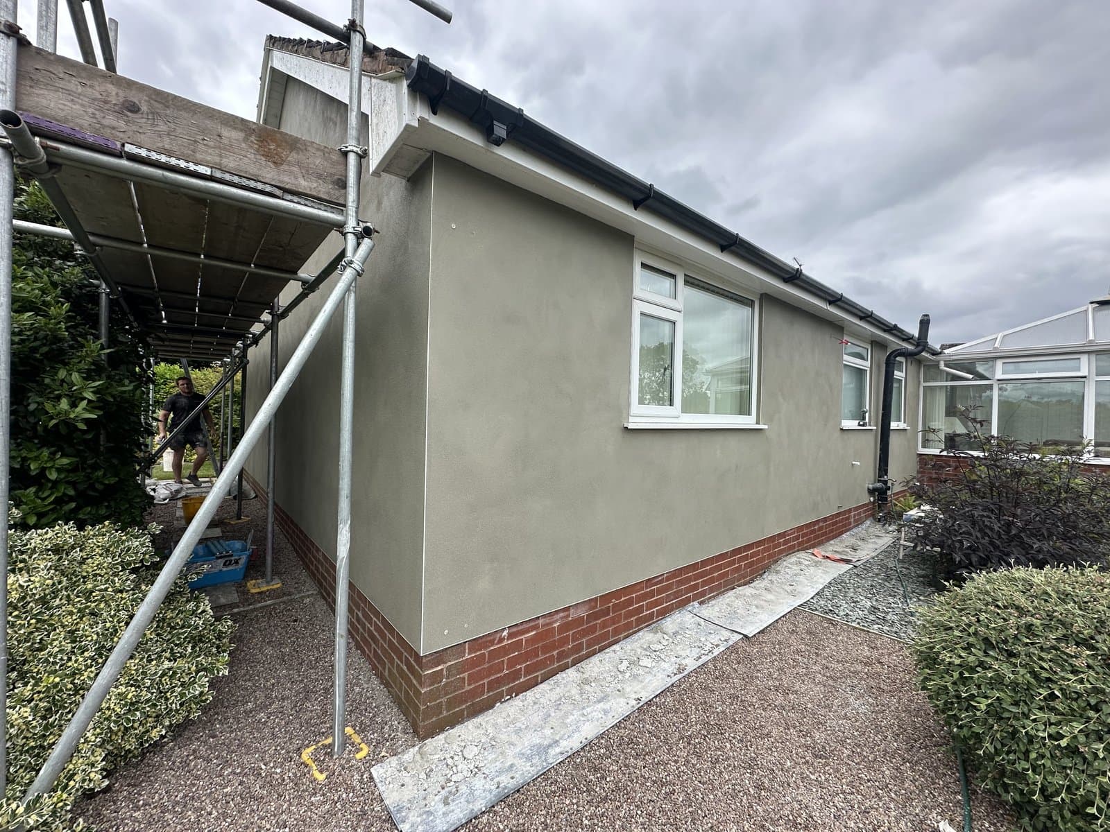 Property being finished in grey traditional smooth render, scaffold still in place